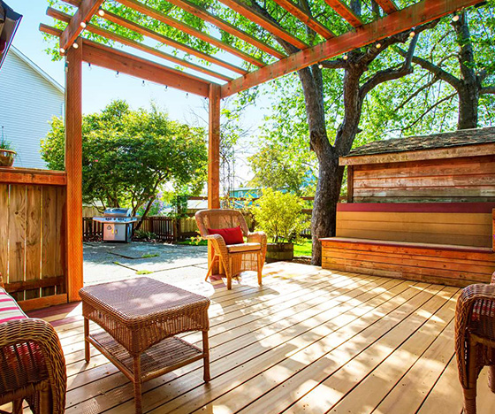 Deck with pergola next to patio