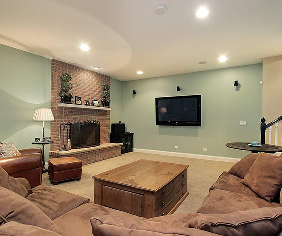 Basement Renovation with green walls and brick fireplace