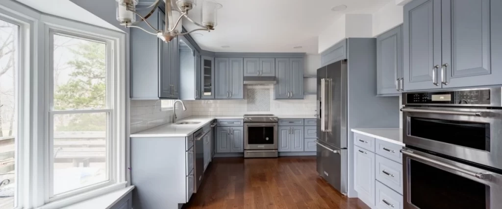 Modern kitchen with gray cabinets, white countertops, and white subway tile backsplash.