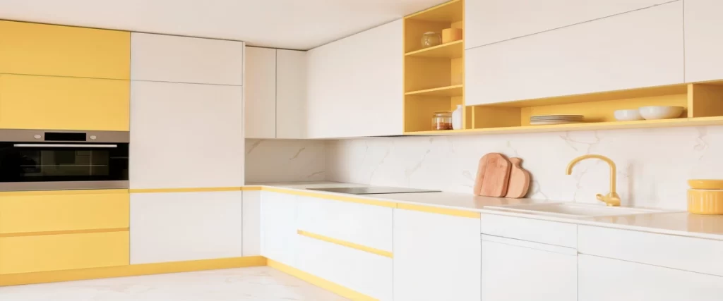 Modern kitchen with white and bright yellow cabinets, white countertops, and a marble-patterned backsplash.
