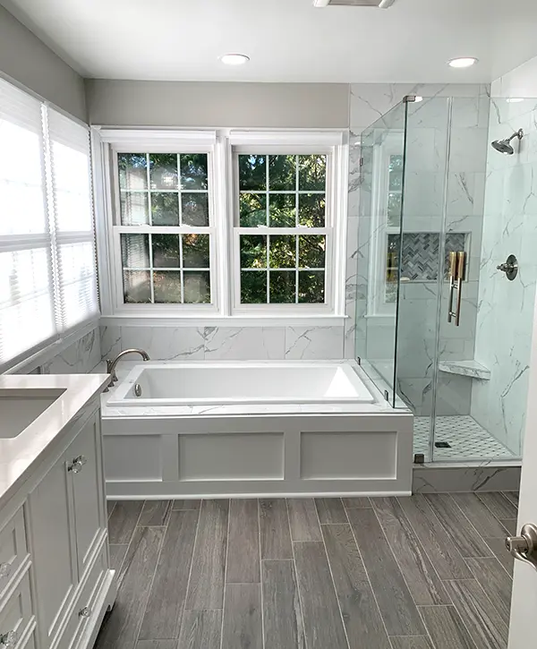 Elegant bathroom remodeling in Manassas with white built-in tub and elegant walk-in shower