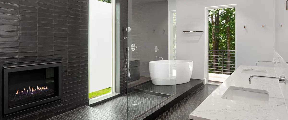 A tub and shower with black tile surround