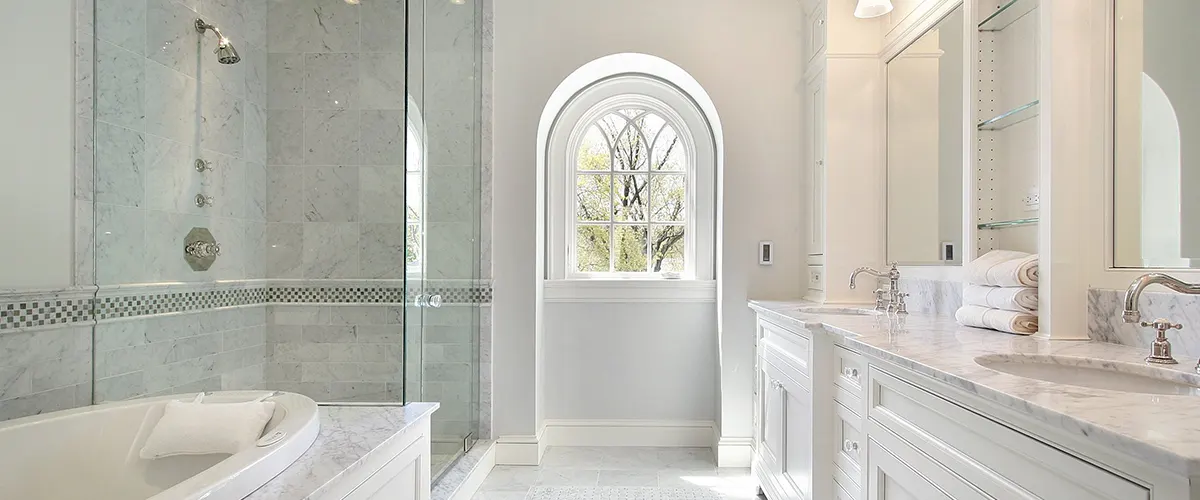 bathroom with white furniture and glass shower