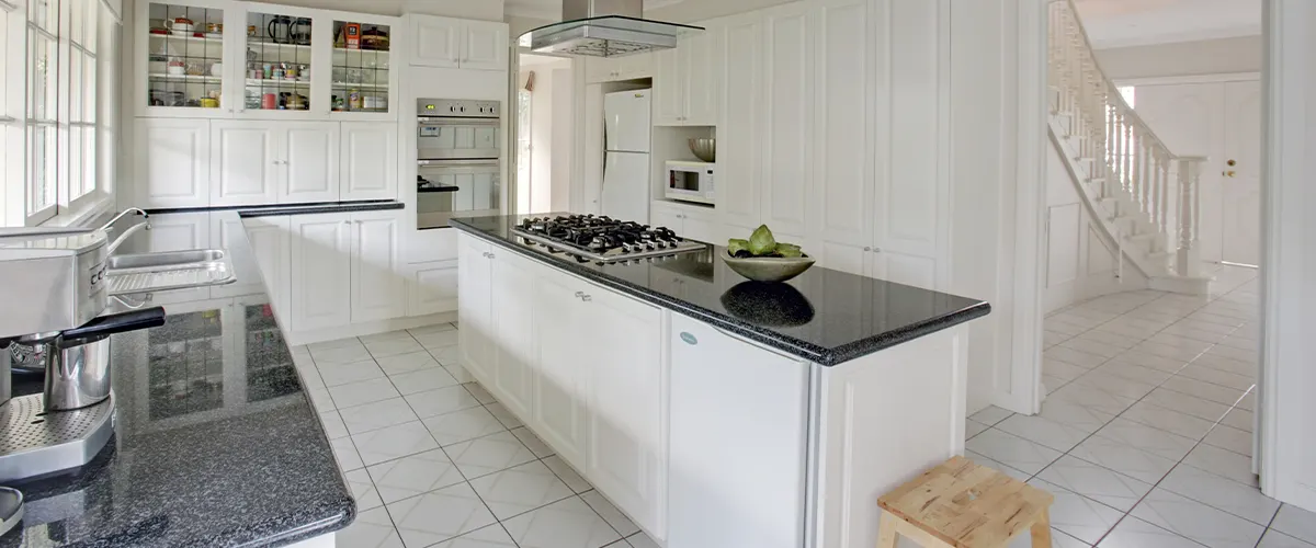 Spacious white kitchen with tile flooring