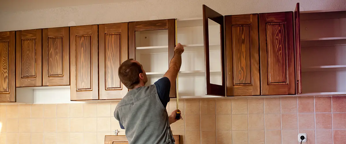 A contractor installing kitchen cabinets