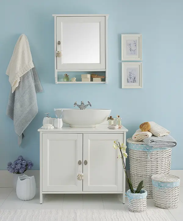 A small bathroom with blue walls and a simple white vanity
