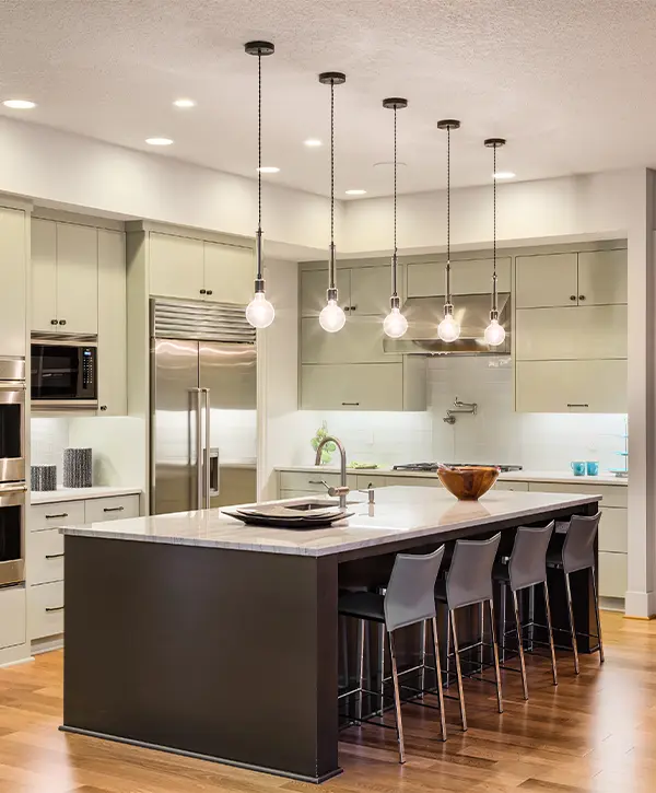 A kitchen remodel with overhang lighting and large kitchen island