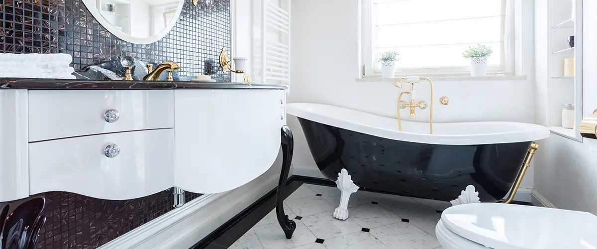 Modern black and white bathroom with golden fixtures and luxury bathtub.