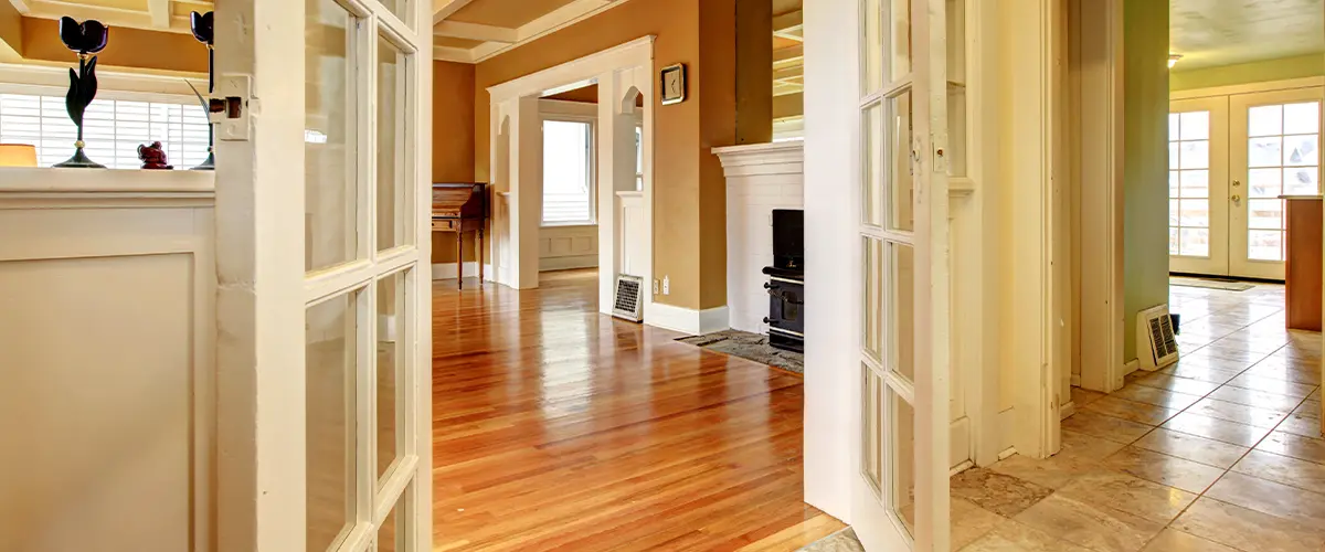 Interior of a classic home with French doors, hardwood floors, and coffered ceilings, perfect for traditional home design and renovation ideas.