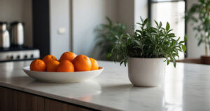 minimalistic kitchen interior details. Stylish white quartz countertop with potted plant and oranges