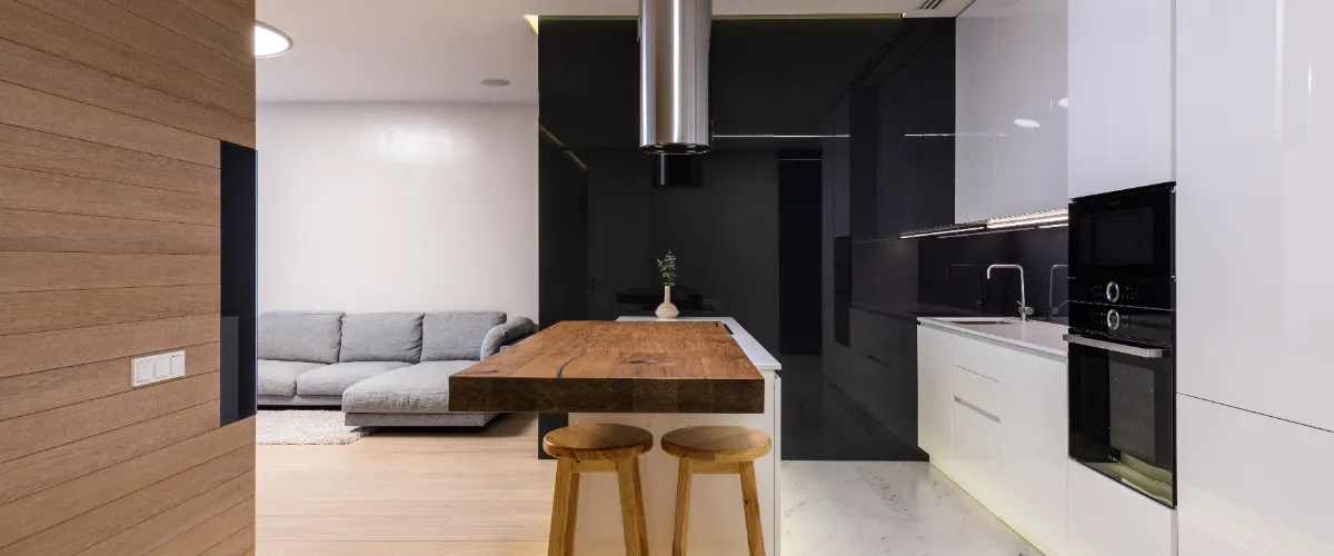 a contemporary open-plan living room and kitchen featuring a minimalist aesthetic with handleless, high-gloss white and black cabinets.