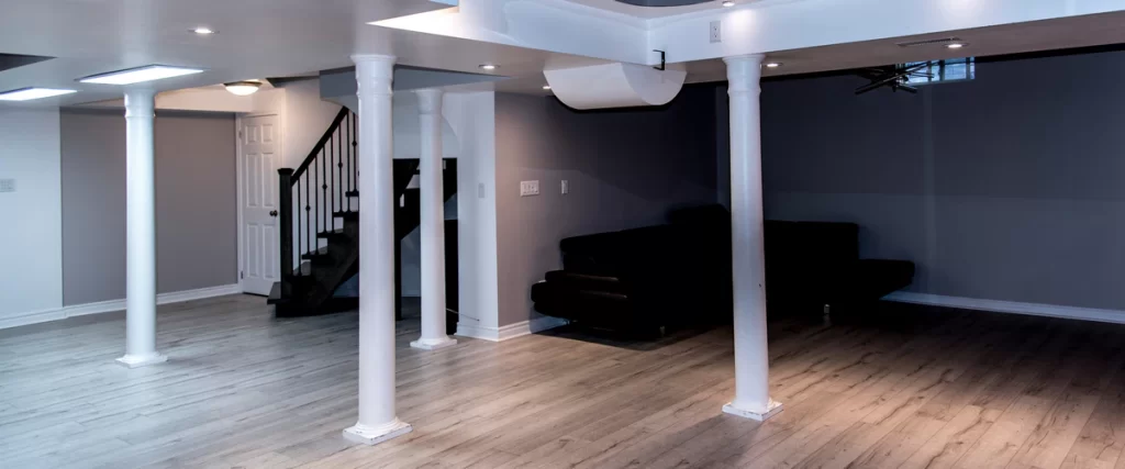 An inviting basement family room set up as a home theater with plush seating and warm ambient lighting.